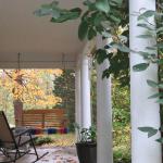 The front porch, which looks over the yard and millrace beyond, welcomes visitors to a gentle porch swing or chairs.